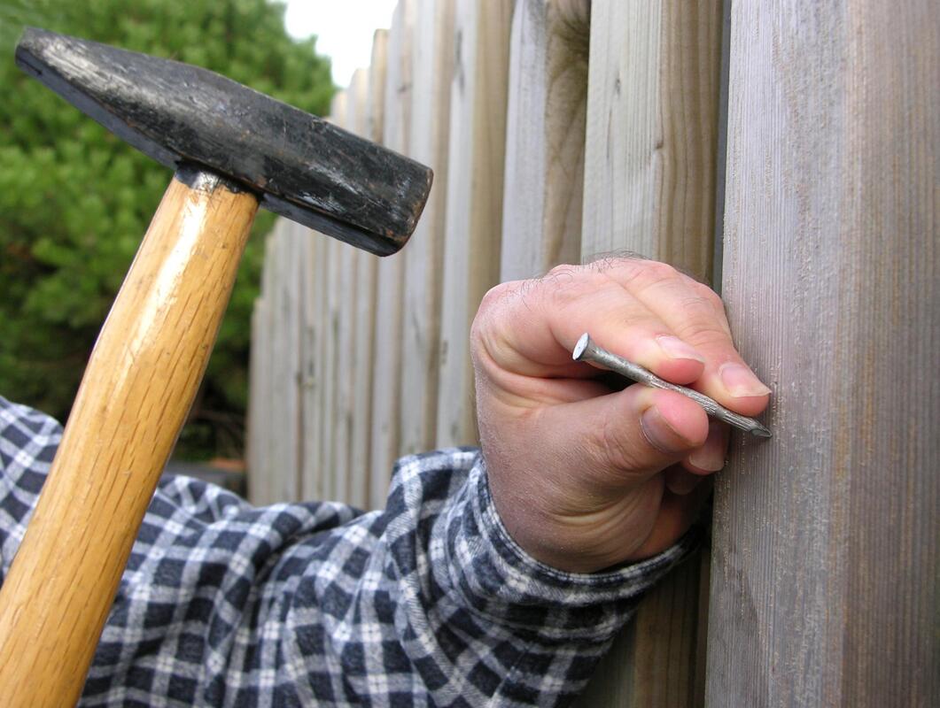 worker nailing the fence